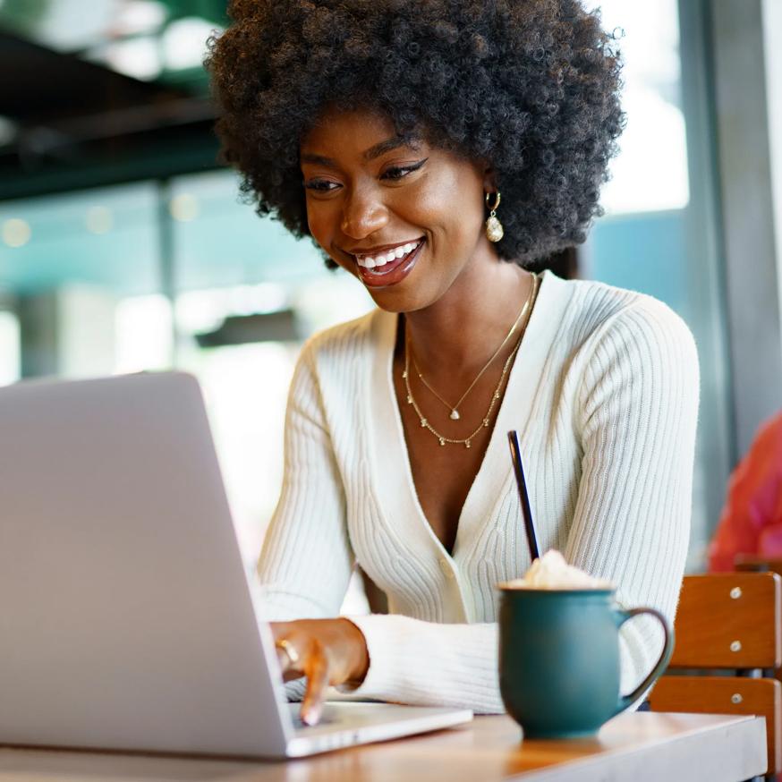 woman drinking coffee and working on laptop modera riverside apartment homes for rent in miami fl