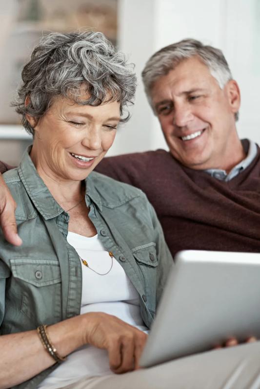 alister sunset valley apartments mature couple sitting on couch looking at computer