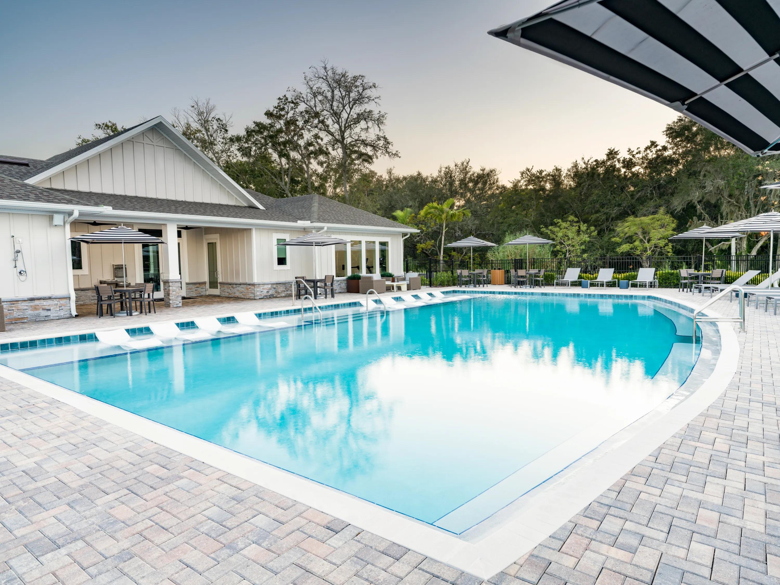 large pool and pool deck area with umbrellas amavi kissimmee single family homes for rent in florida