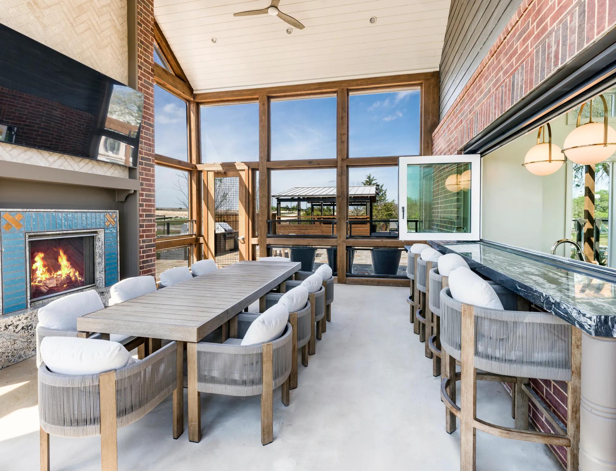screened in porch with seating area and fireplace modera mckinney ridge apartment homes for rent in tx