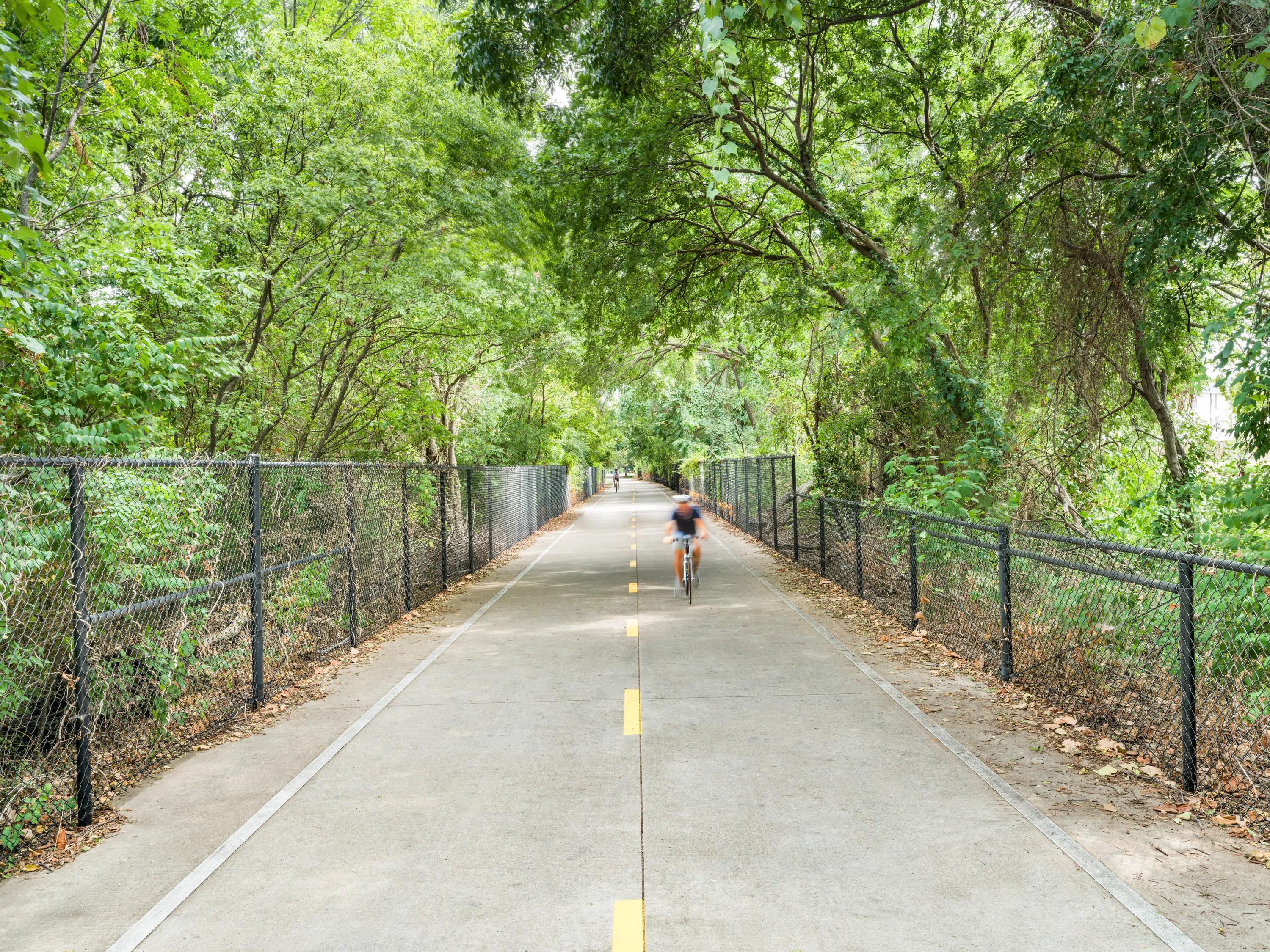 cyclists on pathway riding modera trailhead apartment homes for rent in dallas tx