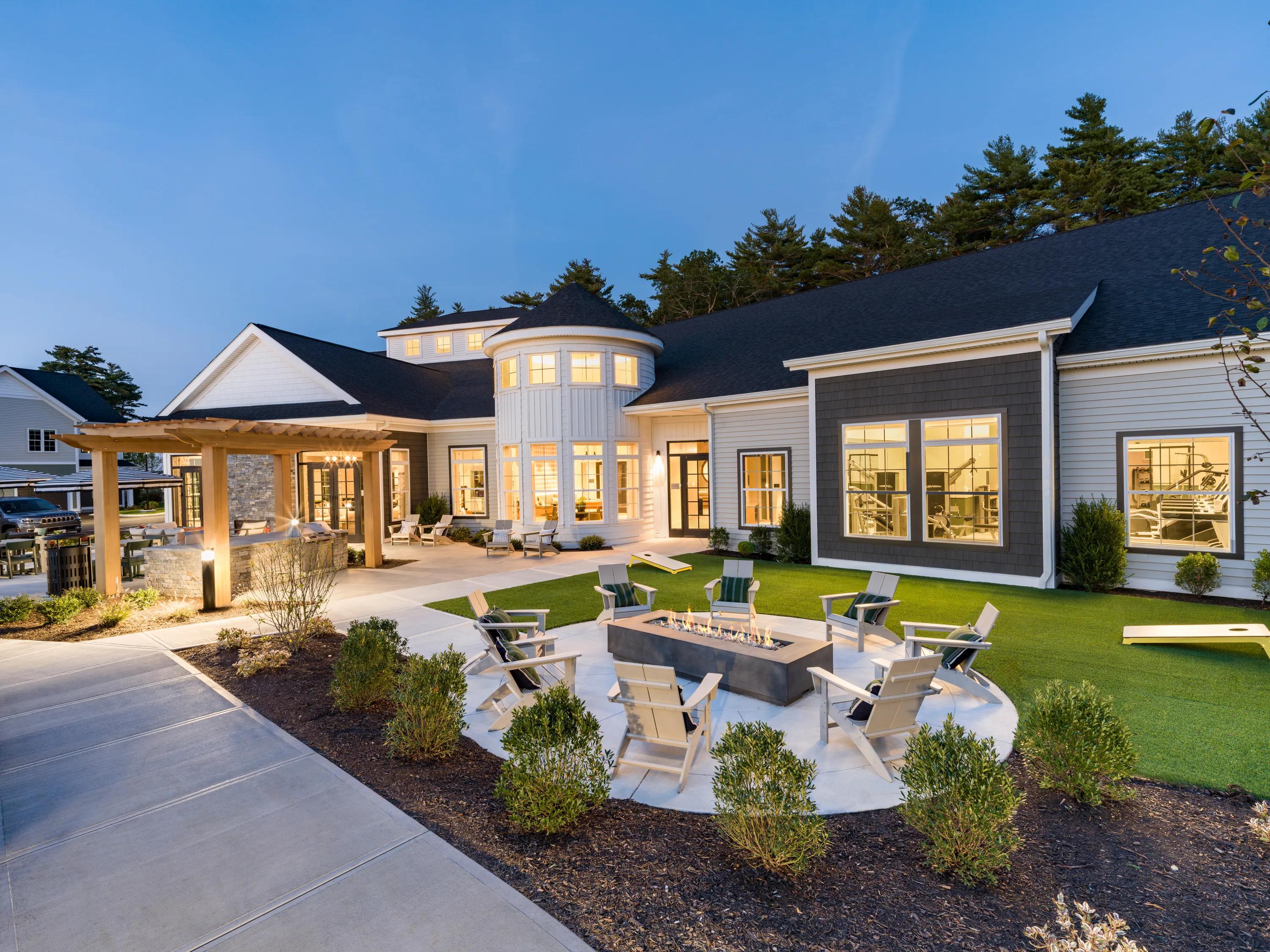 outdoor dining space with umbrellas and fireplace modera south shore apartment homes for rent in marshfield ma