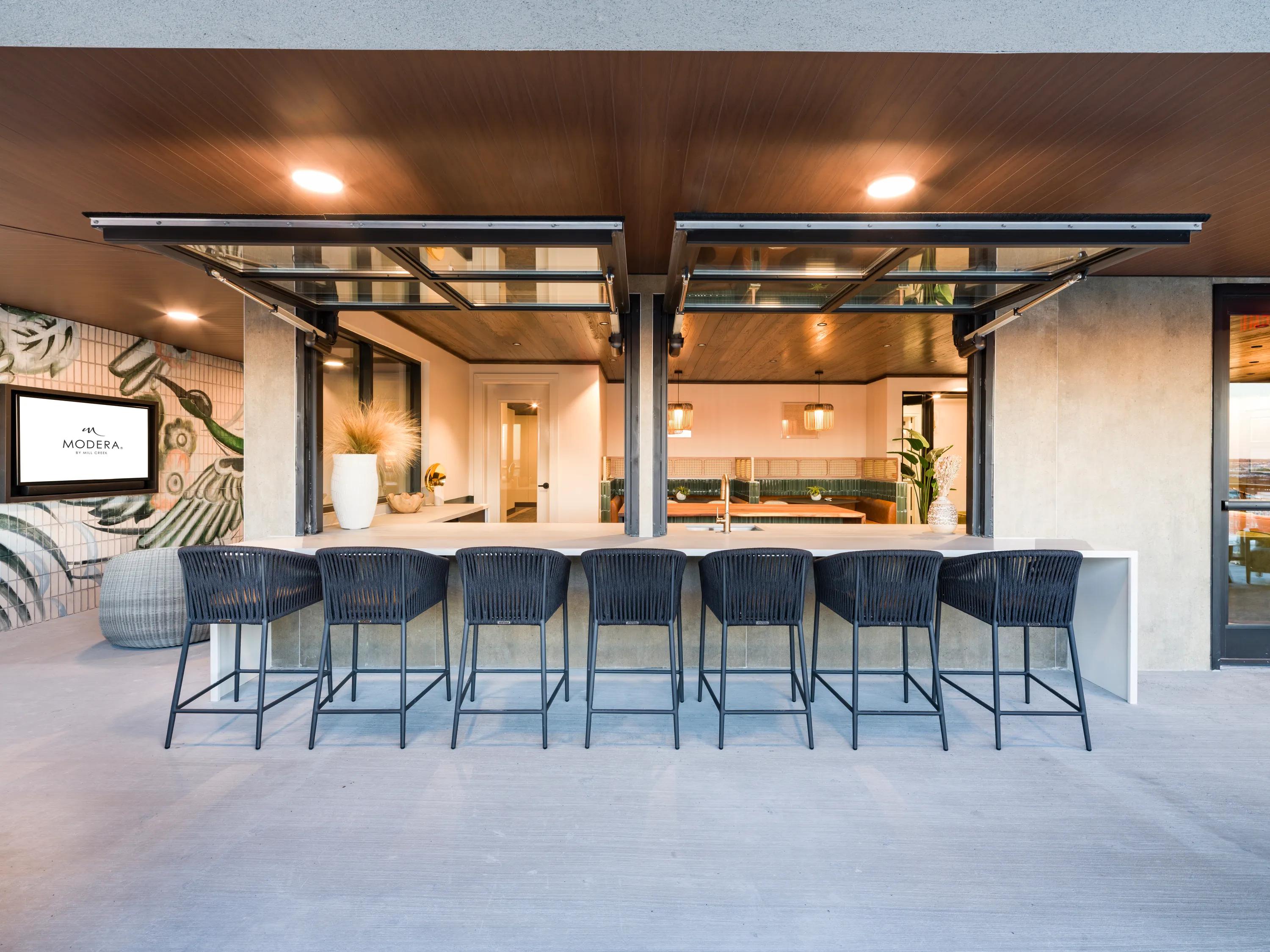 outdoor bar seating looking into indoor loungemodera st paul apartment homes for rent