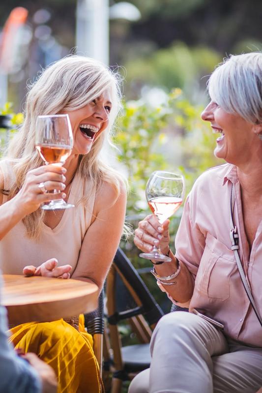 group of mature women drinking wine near the avens at dedham station apartments in ma