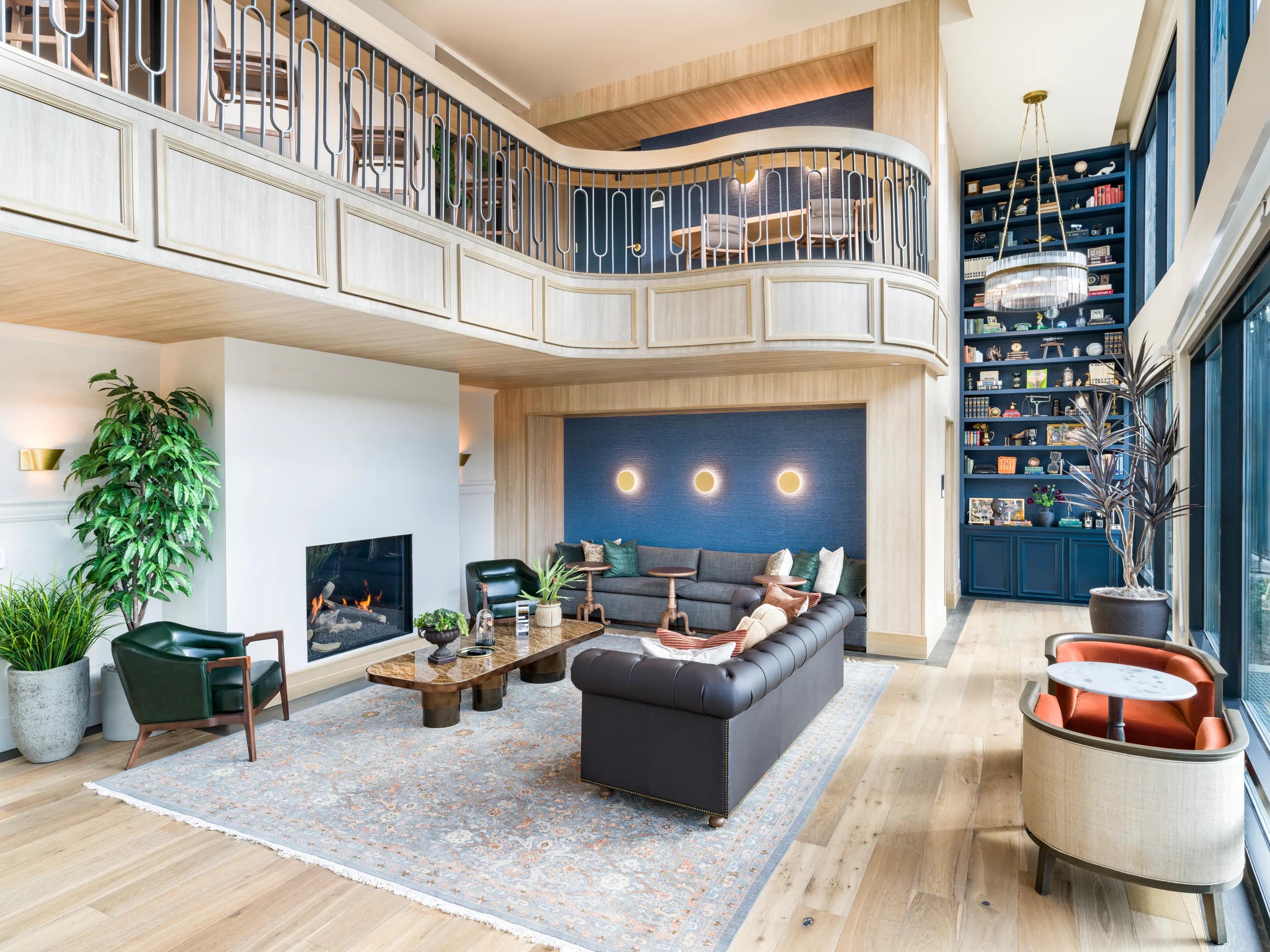 amenity space with fireplace and large bookshelf with windows at modera university park apartment homes for rent in denver co
