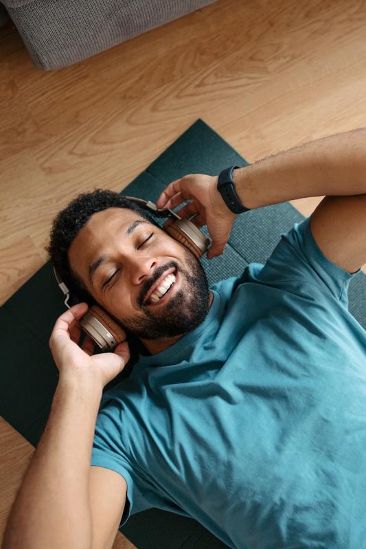 young man laying on yoga mat listening to music and smiling vespaio apartments