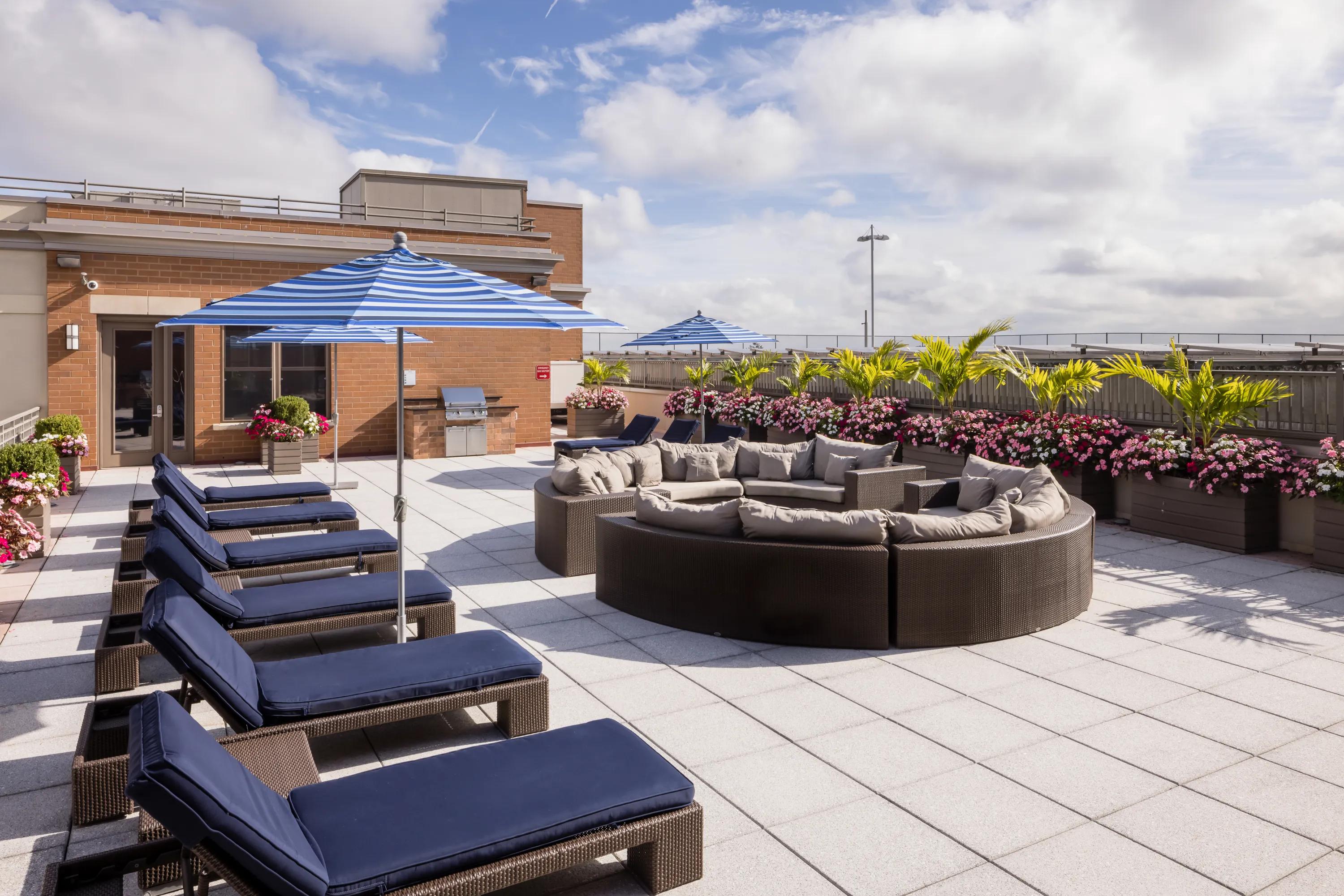 flowers and plants on rooftop adjacent to sectional and lounge seating metropolitan at 40 park apartment homes for rent in morristown nj
