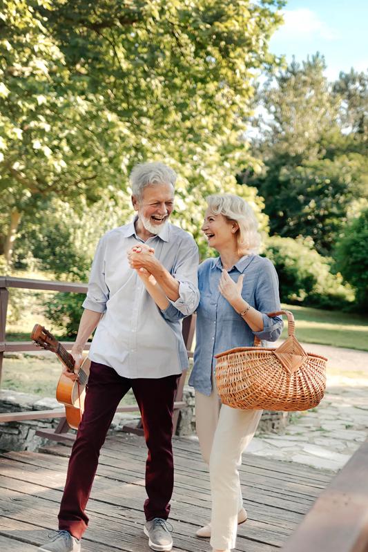 mature couple walking across a bridge in a park preparing for a picnic modera walsh heights apartments in aledo tx