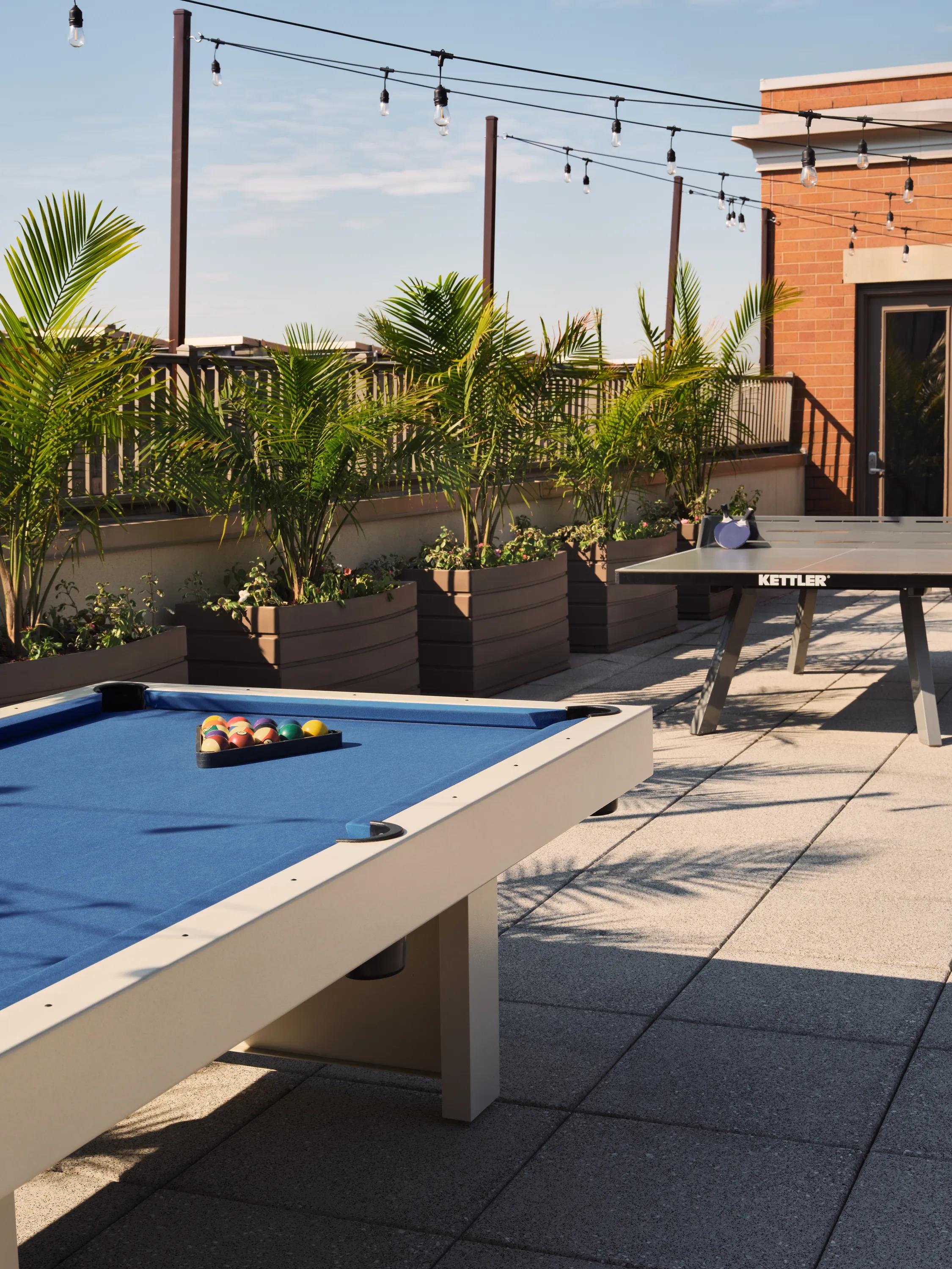 rooftop gaming table on sunny day metropolitan at 40 park apartment homes for rent in morristown nj