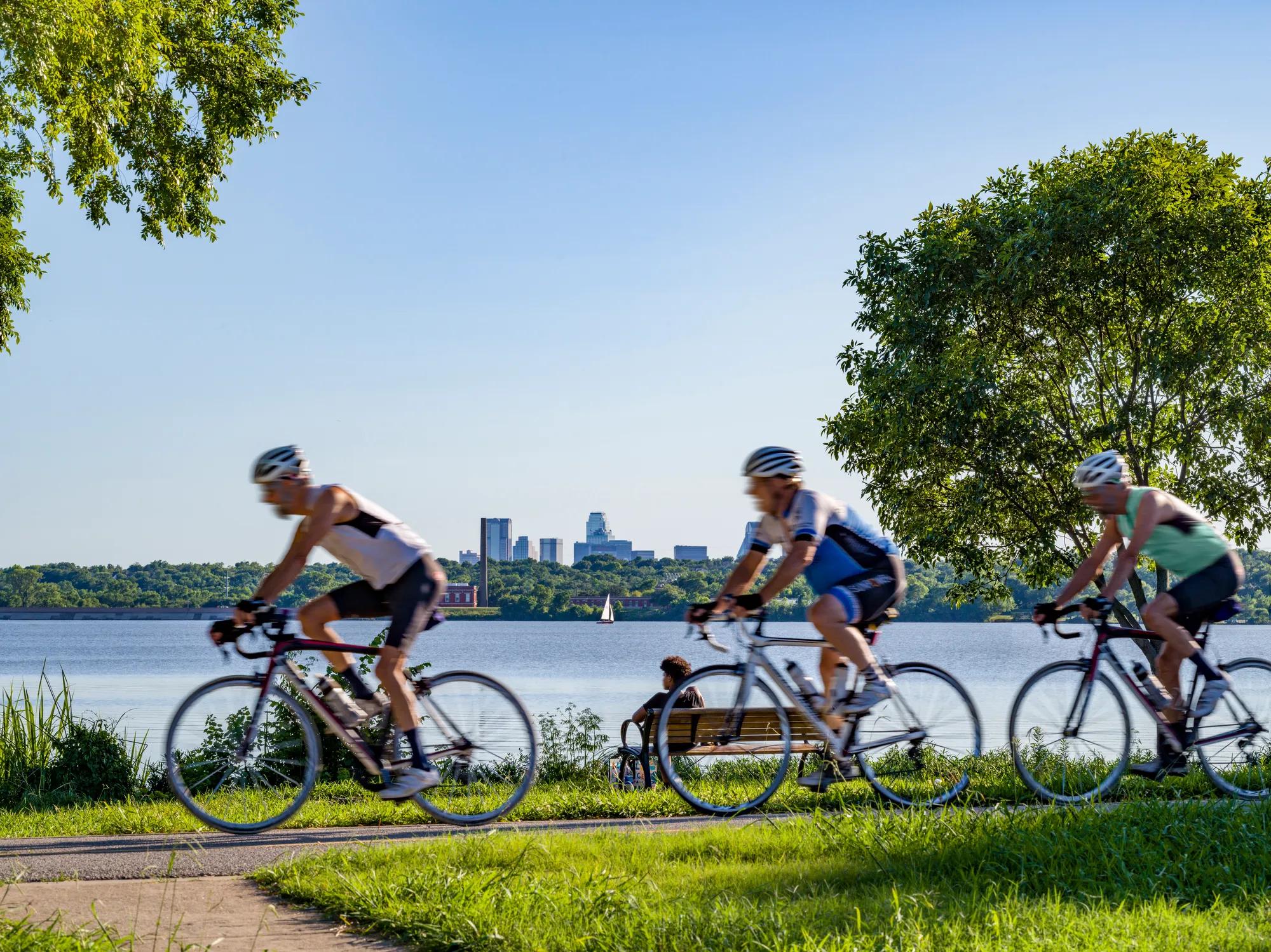 cyclists on pathway riding around body of water modera trailhead apartment homes for rent in dallas tx