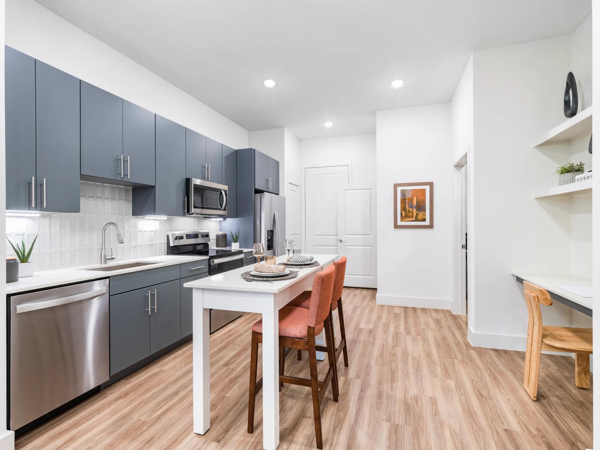 Large kitchen space with custom cabinetry, tile backsplash, and stainless steel appliances
