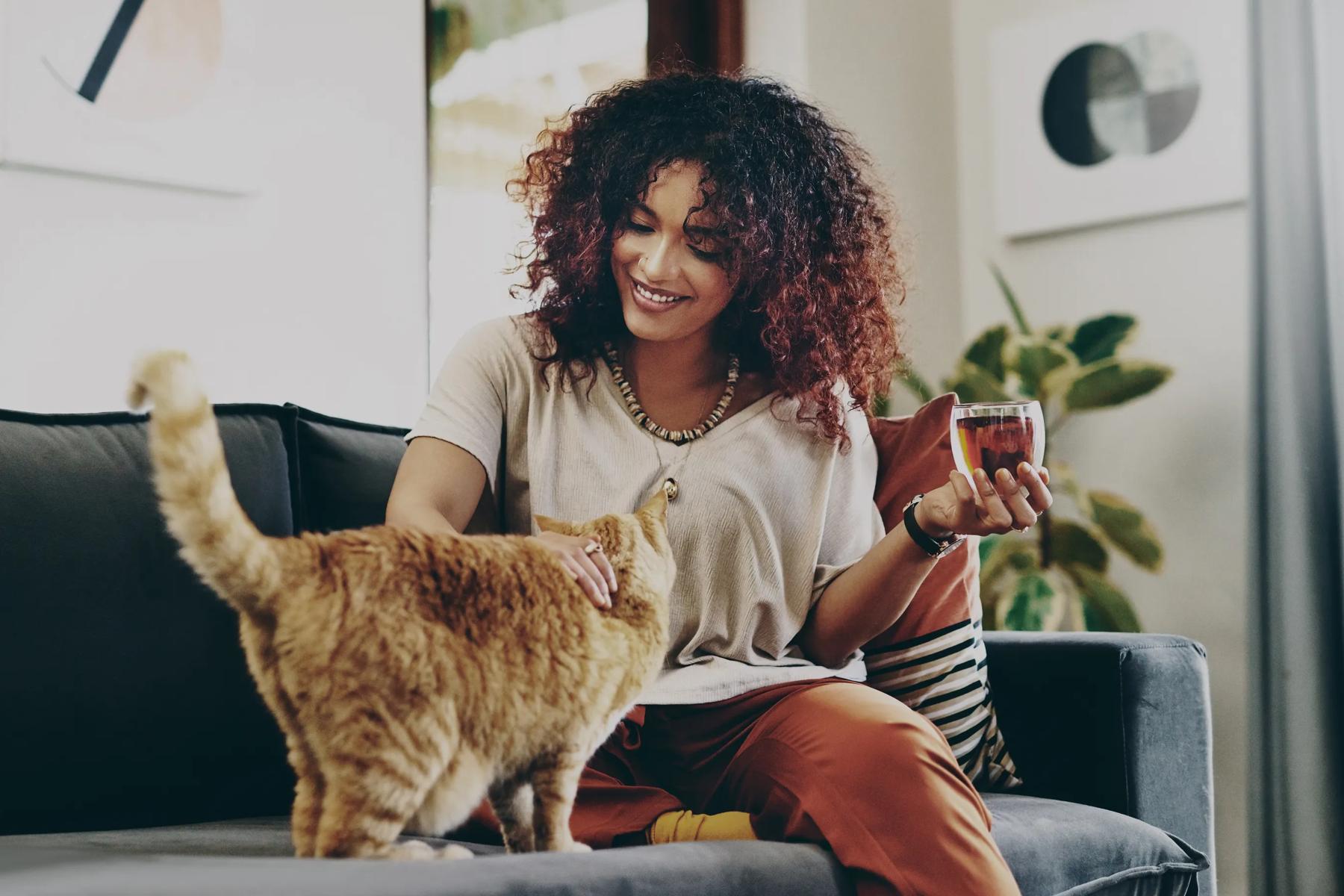 woman petting cat inside apartments home while holding wine glass apartments in scottsdale az modera scottsdale
