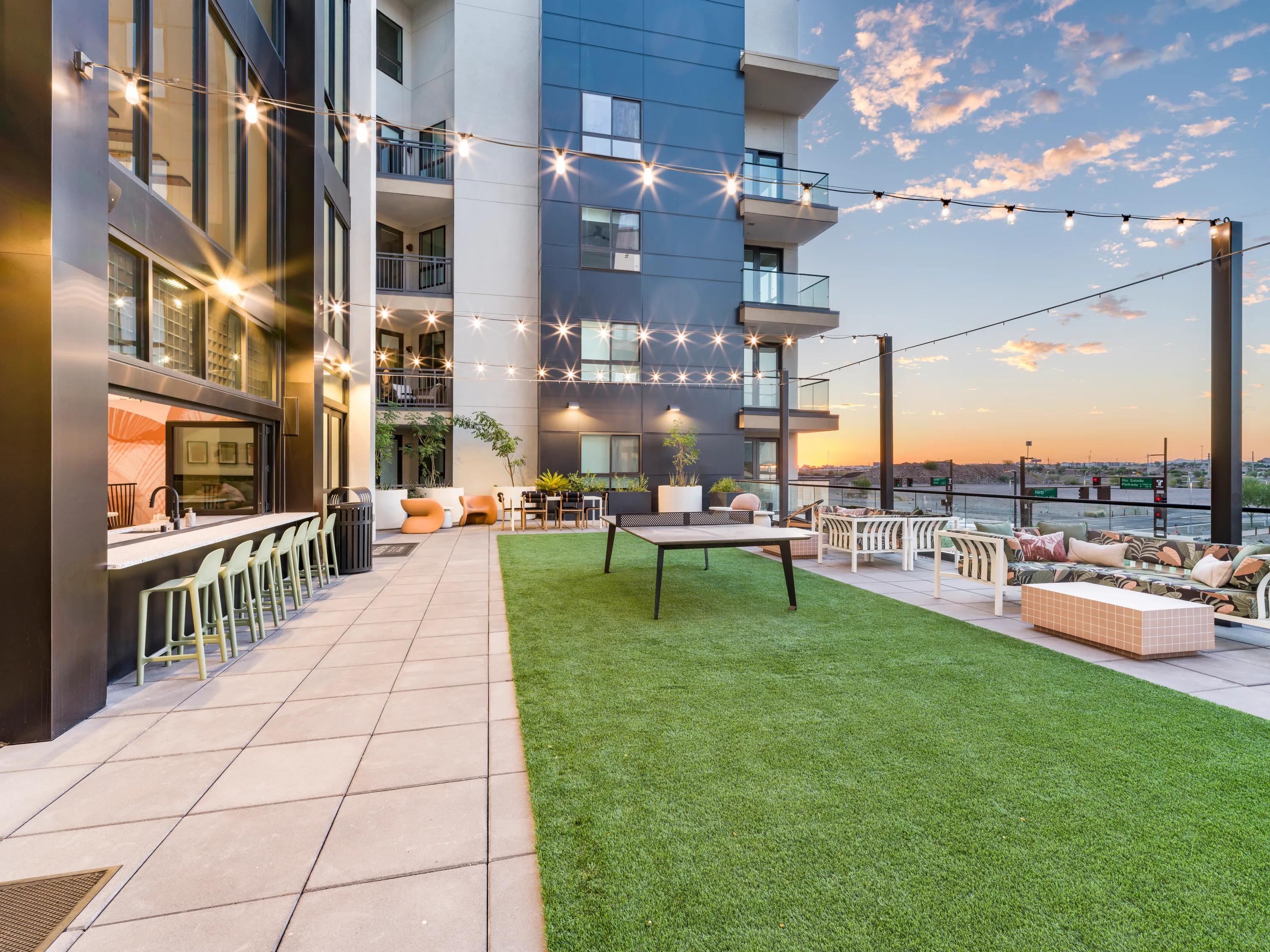 Outdoor courtyard with grilling areas, activity lawns, and lounge seating with firepit modera rio salado