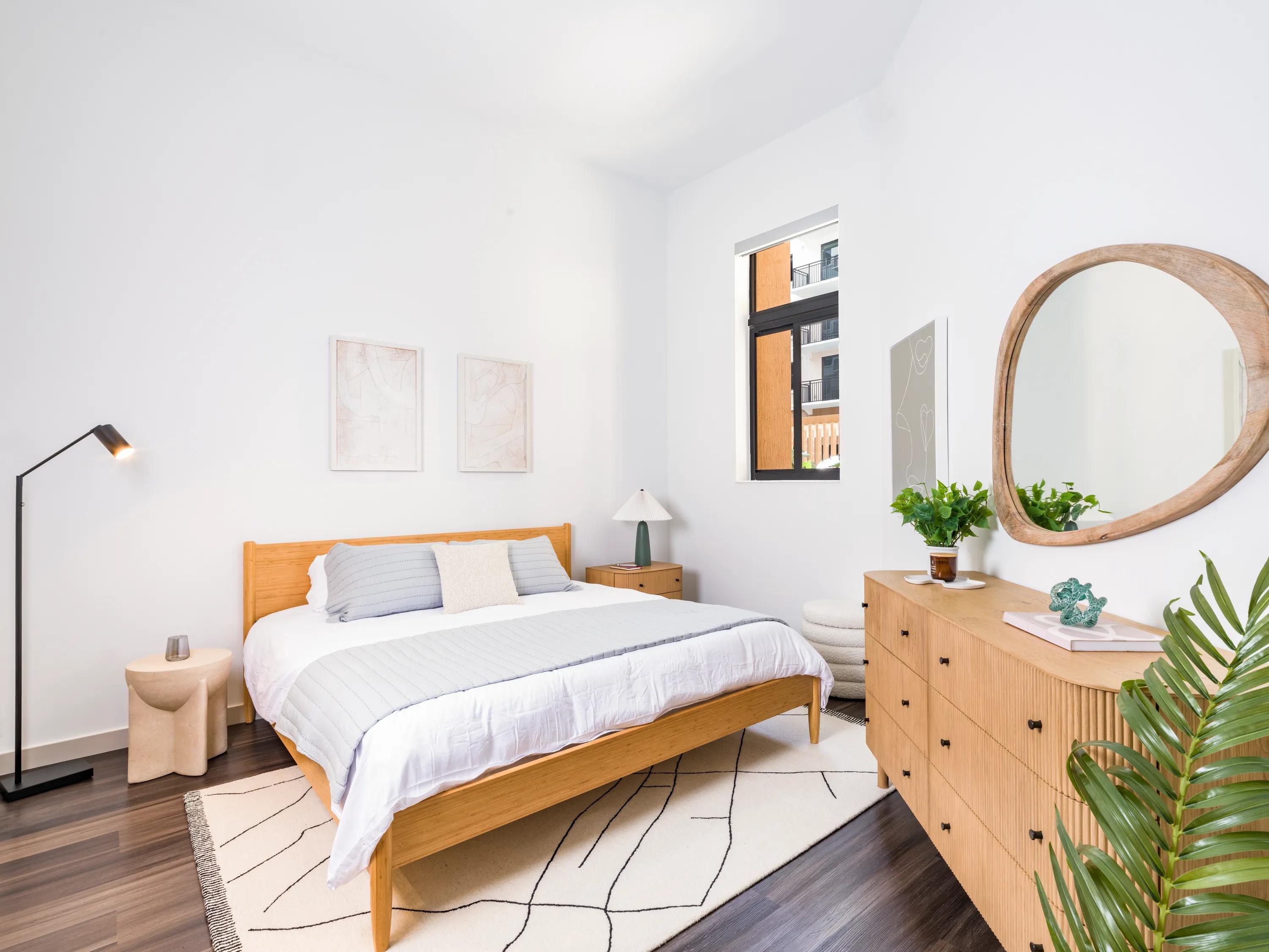 bedroom with furniture and large window at modera academical village apartment homes for rent in davie fl