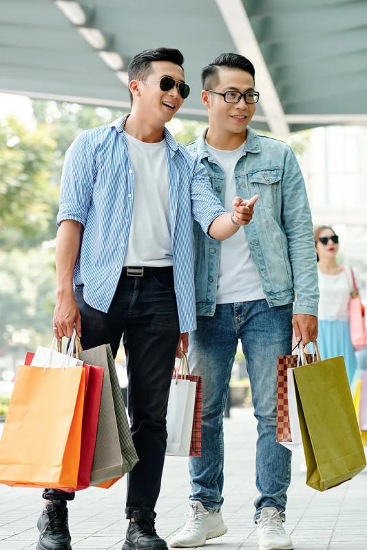 two men holding shopping bags outdoor while one is pointing at a store and the other is looking modera west wash park denver co