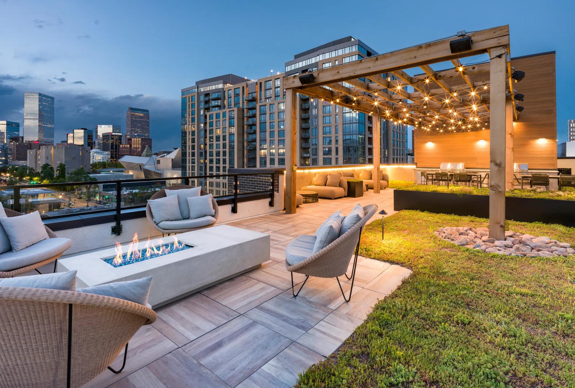 firepit on rooftop lounge with greenspace at night with city views modera golden triangle apartment homes for rent in denver co