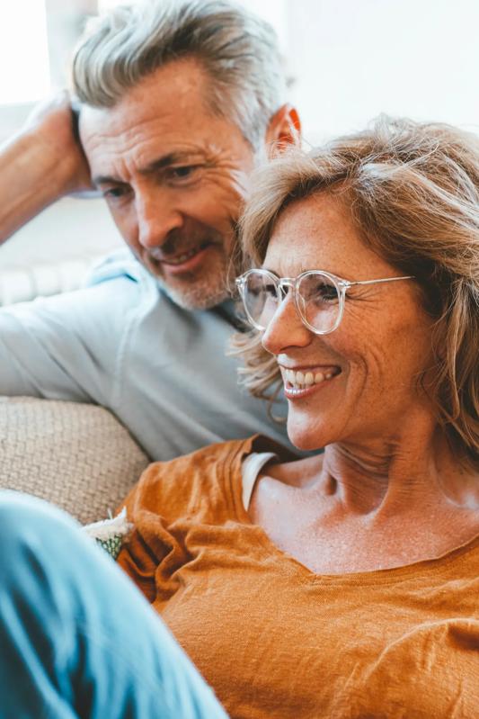 mature adults sitting on couch looking at tablet modera needham apartment home boston ma