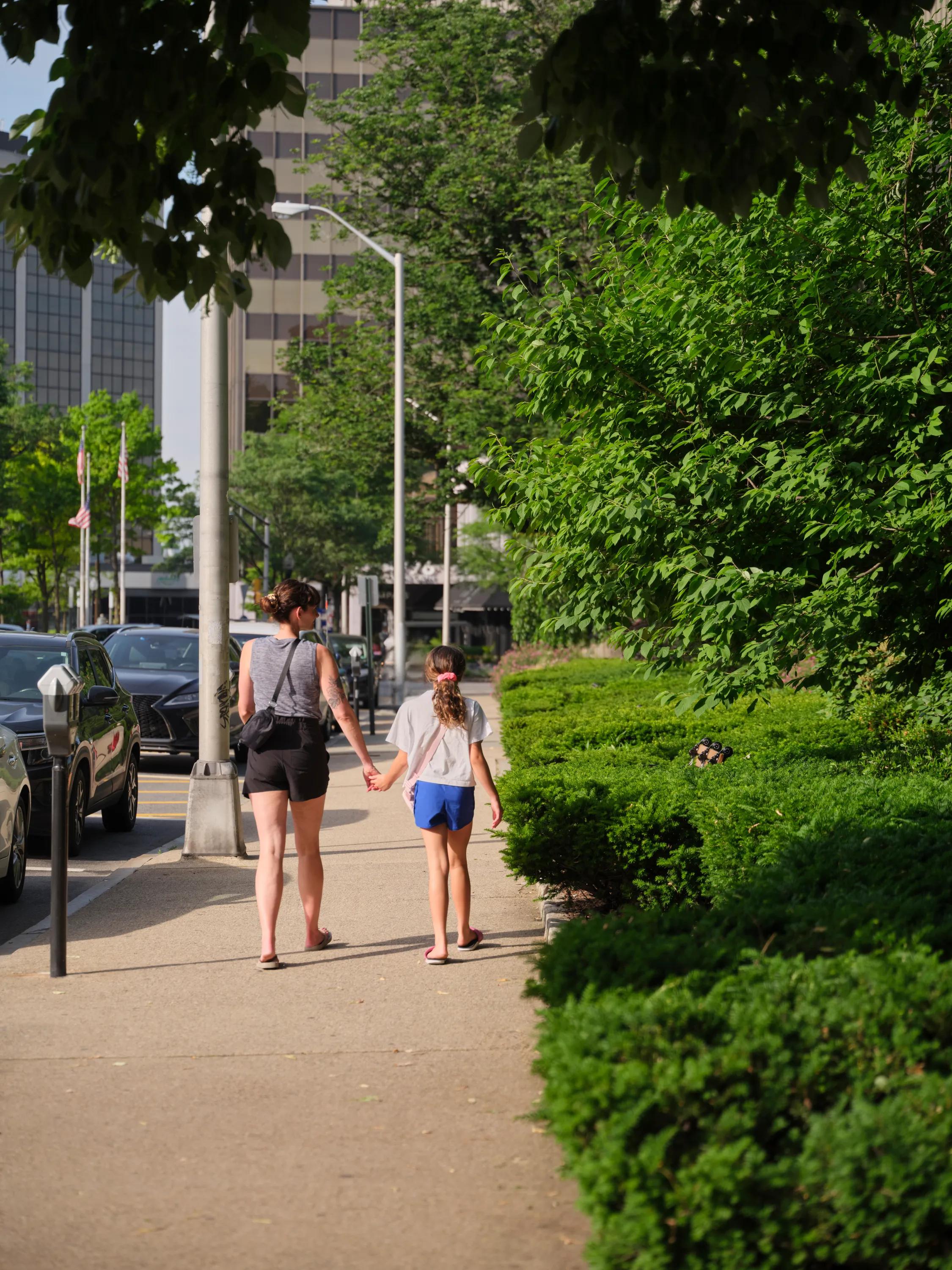 mother and daughter holding hand while walking down street metropolitan at 40 park apartment homes for rent in morristown nj