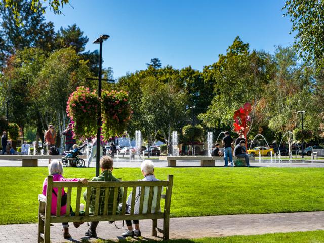 three people sitting on bench in park modera beaverton apartment homes for rent in or