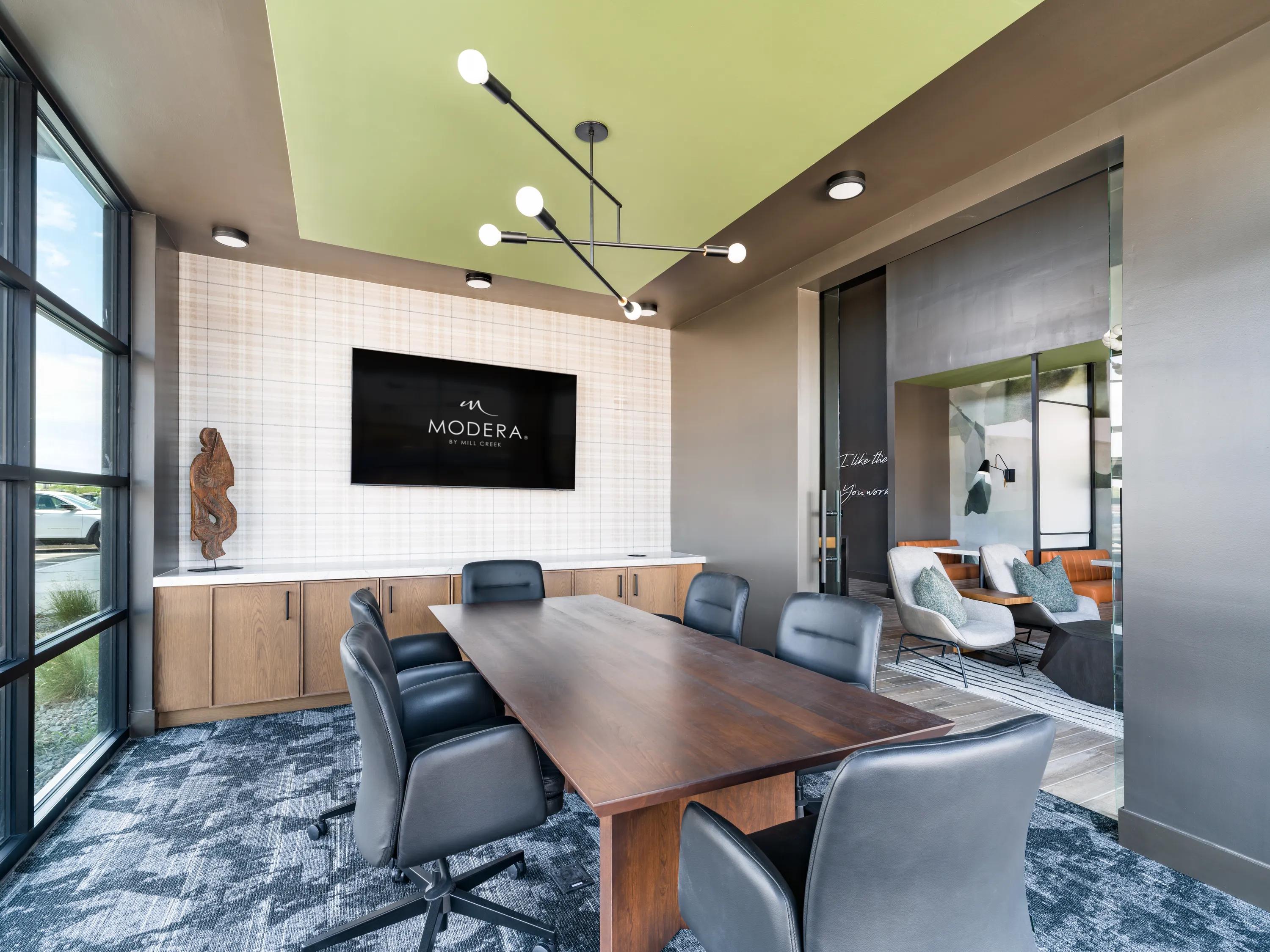 Private conference room with a large meeting table, executive seating, integrated display screen, contemporary lighting, and modern finishes at apartments in Chandler, AZ.